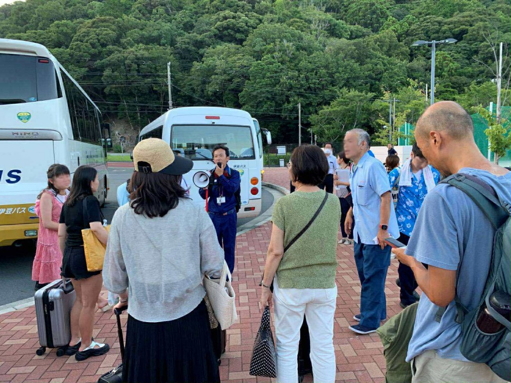 外国人観光客を臨時バスに誘導する著者